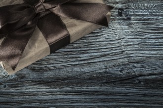 Wrapped brown present box on wooden board