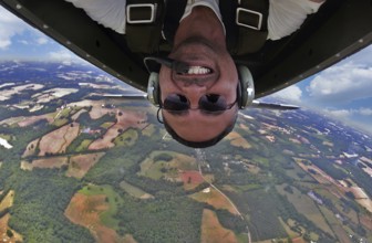A WWII pilot captures a daring selfie mid-flight, executing precise aerial maneuvers in a classic
