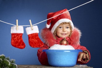 Child in Santa hat washing in basin. Christmas concept