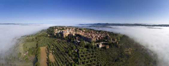 Old Italian city on top of a hill in the fog. Aerial panorama view in Tuscany