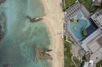 Drone aerial of luxury holiday hotel resort and sandy tropical beach in winter
