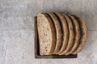 Slices of whole grain bread lie in a square wooden box, copy space, selective focus