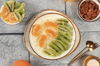 Healthy breakfast with ingredients, Rice pudding with kiwi, honey, tangerines and almonds.flat lay,