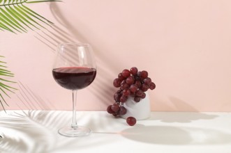 Modern still life with red wine, margarita alcoholic cocktail and grapes on a pastel background