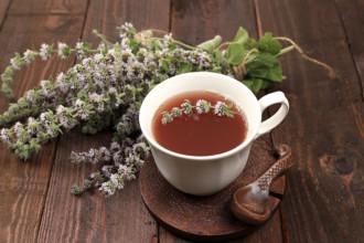 Flower tea with mint on an old wooden table, has a calming and relaxing effect, alternative