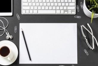 Top view of modern workplace with blank paper sheet. Flat lay black surface with smartphone,