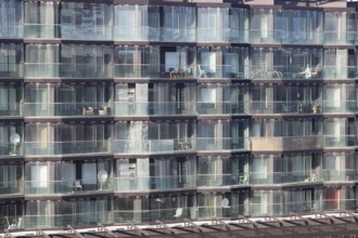 Architectural background of the exterior of a modern apartment block with large glass windows and