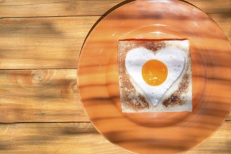 Breakfast of toast and eggs in the shape of heart