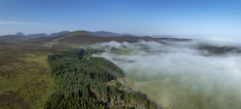 Coastal fog in the Scottish Highlands with hills, in the background prominent peak of Morven,