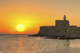 The sunrise at the entrance with the deers of the old port of Rhodes, Greece