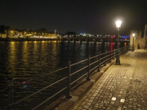 River course at night, illuminated by lights and reflecting water surface, maastricht, the