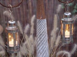 Rustic metal lanterns with burning candles that provide a warm source of light, weseke,