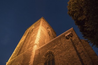 Night shot of an illuminated church tower with an atmospheric ambience, utrecht, the netherlands