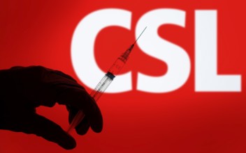 A gloved hand holding a syringe in front of the CSL logo. CSL Limited is an Australian