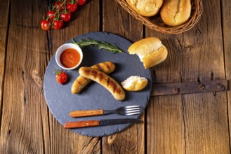 Rustic bratwurst with ketchup and fresh rolls