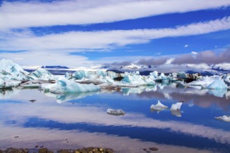 Clouds reflected in the smooth water of the largest glacial lagoon Jokulsaurloun. Iceland. Cold