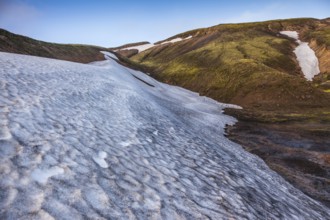 Summer morning in the National Park Landmannalaugar, Iceland. Big unmelted in July snowfield