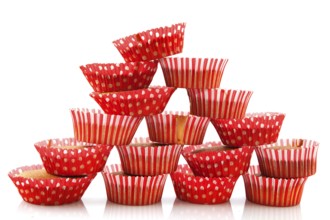 Many home made cup cakes stacked and isolated over white