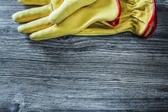 Leather safety gloves on wooden board
