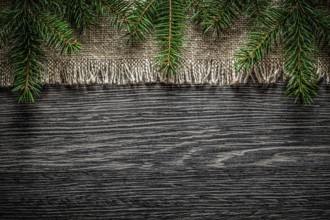 Vintage hessian pine branch on wooden board Christmas background