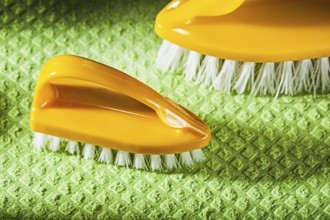 Set of new plastic brushes on green dishcloth
