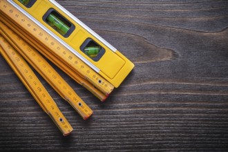 Set of yellow construction level with wooden meter on vintage wood board maintenance concept