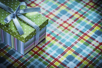 Present box on colorful checked tablecloth celebrations concept