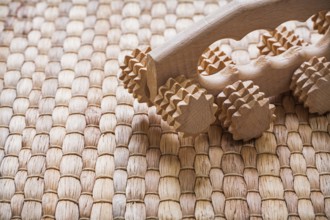 Wooden relaxing massager on wicker background sauna concept
