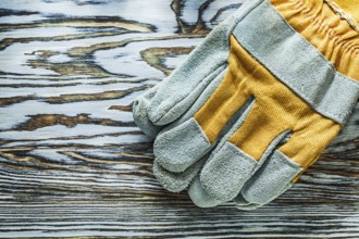 Pair of safety gloves on wooden board