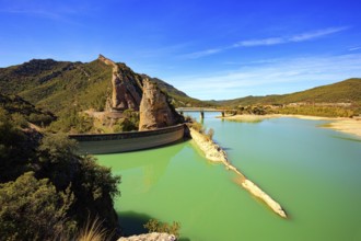 Picturesque conical rocks and a bridge over the reservoir. Magnificent dam collects the water of