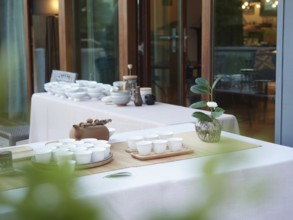 Elegant break at events. Tables with outdoor tea service, teapot and white cups