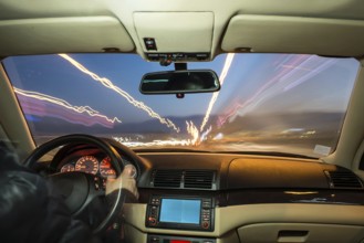 Car interior on driving. Blurred night lights