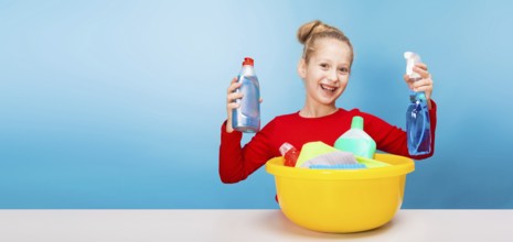 Isolated on blue, cheerful girl in red pullover with fair-haired updo, holding in both hands a