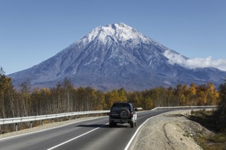KAMCHATKA, RUSSIA, SEPTEMBER 30, 2012: Autumn view of car driving on road to active Koryaksky