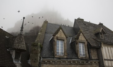 Mont-Saint-Michel, monastery hill, Grand Rue, roofscape above the abbey in the mist