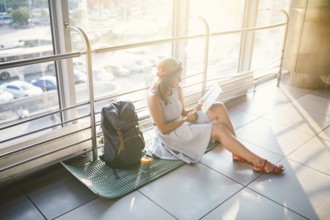 Waiting, delayed transport in the terminal of the airport or train station. Young caucasian woman