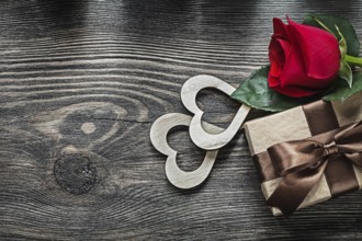Wooden hearts red rose gift box on wood board celebrations concept
