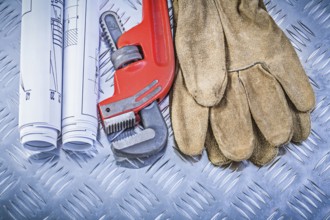 Monkey wrench construction drawings leather safety gloves on corrugated metal background building