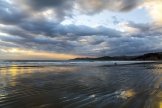 Sunrise over the ocean. Low tide. Strips of sand and water left by the ocean tide. New Zealand,