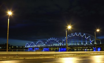 Railway bridge at night with citylights and dark sky