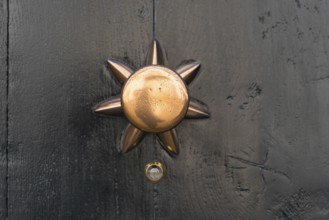 Closeup of a copper doorknob with a small peephole under it