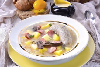 A polished Easter soup with homemade white sausages and mushrooms