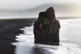 Detail of Arnardrangur rock in the middle of peninsula near Reynisfjara Beach view point Dyrholaey