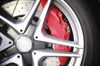 Close-up of the spoke rims of a sports car with brake discs