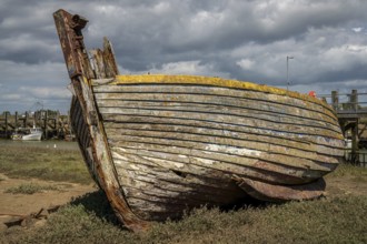Rye Harbour, East Sussex, England, UK, May 12, 2022: An old shipwreck and some boats on the banks