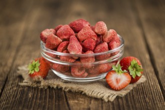 Strawberries (dried) as high detailed close-up shot on a vintage wooden table, selective focus