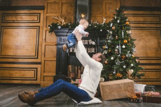Happy father and son at home near Christmas tree. New Year and Christmas theme. Holiday mood.