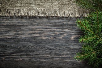Vintage sackcloth pine branch on wooden board Christmas background