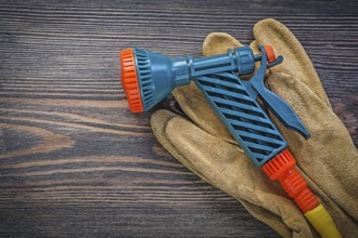 Water sprinkler safety gloves on wooden board agriculture concept