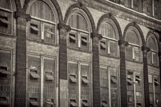 Old power plant - windows and brick walls with sandstone decoration, sepia toned black and white